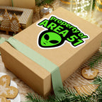 Wooden gift box with 'Property of Area 51' alien sticker on a festive background with cookies and decorations.